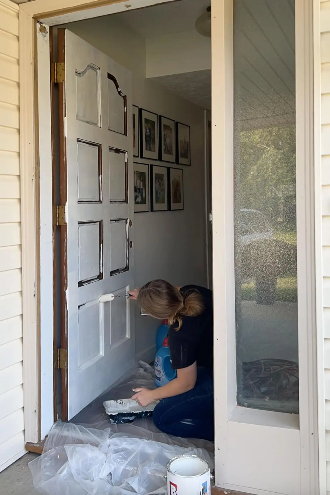 Priming a front door before painting.